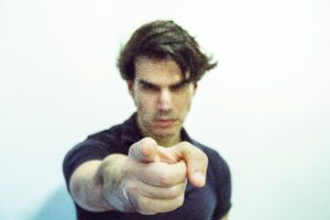 A man pointing at the camera with his finger.