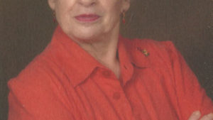 A woman in red shirt with arms crossed.