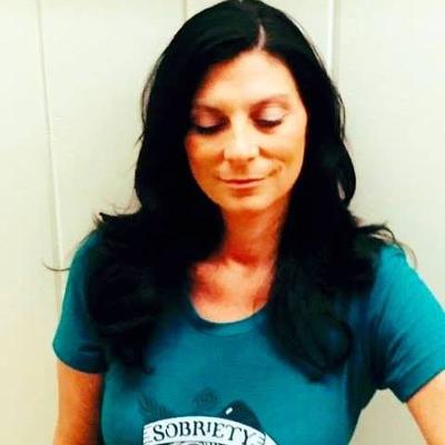 A woman with long black hair wearing a blue shirt.