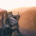 A person standing on top of a cliff.