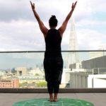 A woman standing on top of a green mat.