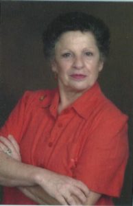 A woman in red shirt with arms crossed.