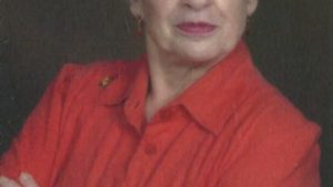 A woman in red shirt with arms crossed.