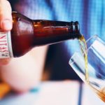 A person pouring beer into a glass.