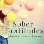A woman holding balloons with the words sober gratitudes in front of her.