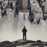 A man standing on top of a mountain looking at the city.