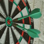 A close up of three arrows on a dart board